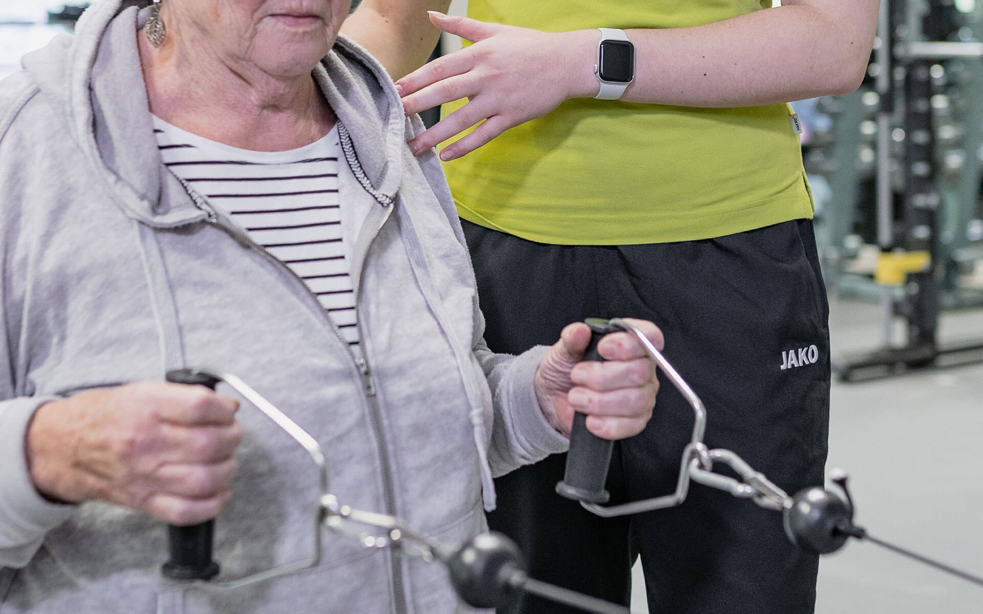 Therapeutin unterstützt Patientin beim Arm Training