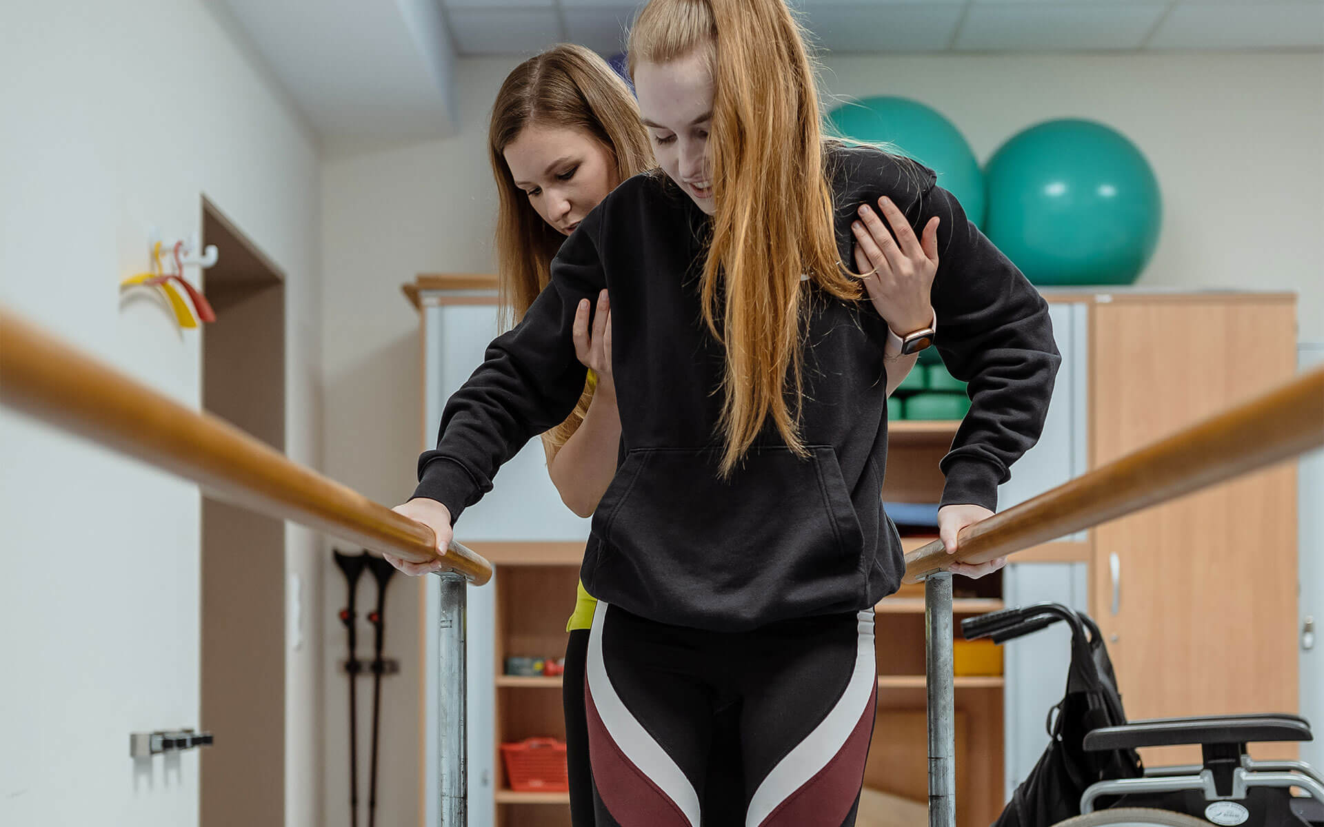 Patientin lernt am Barren laufen